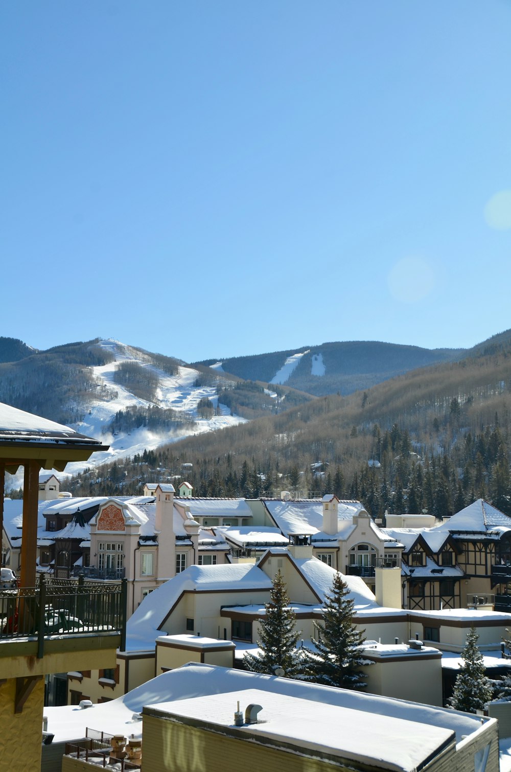 white and brown house near snow covered mountain during daytime