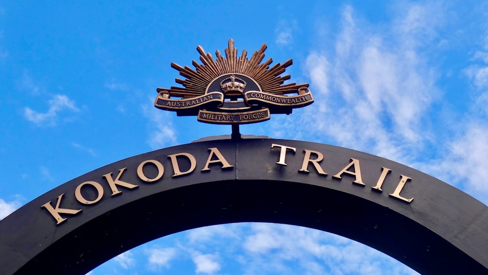 Un cartello che dice Kokoda Trail con uno sfondo del cielo