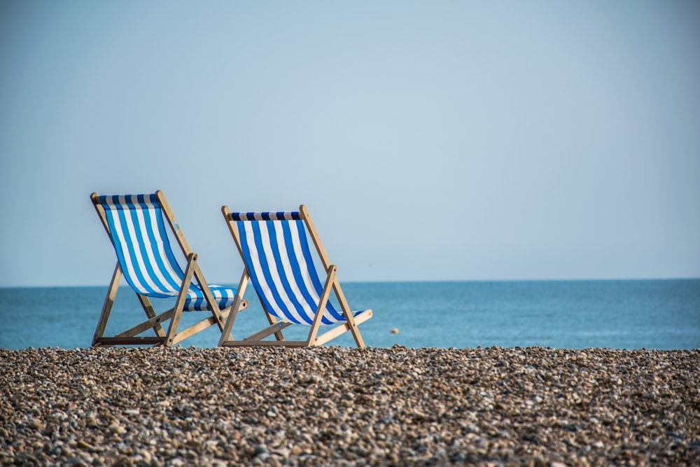 blue and white striped folding chair on beach during daytime