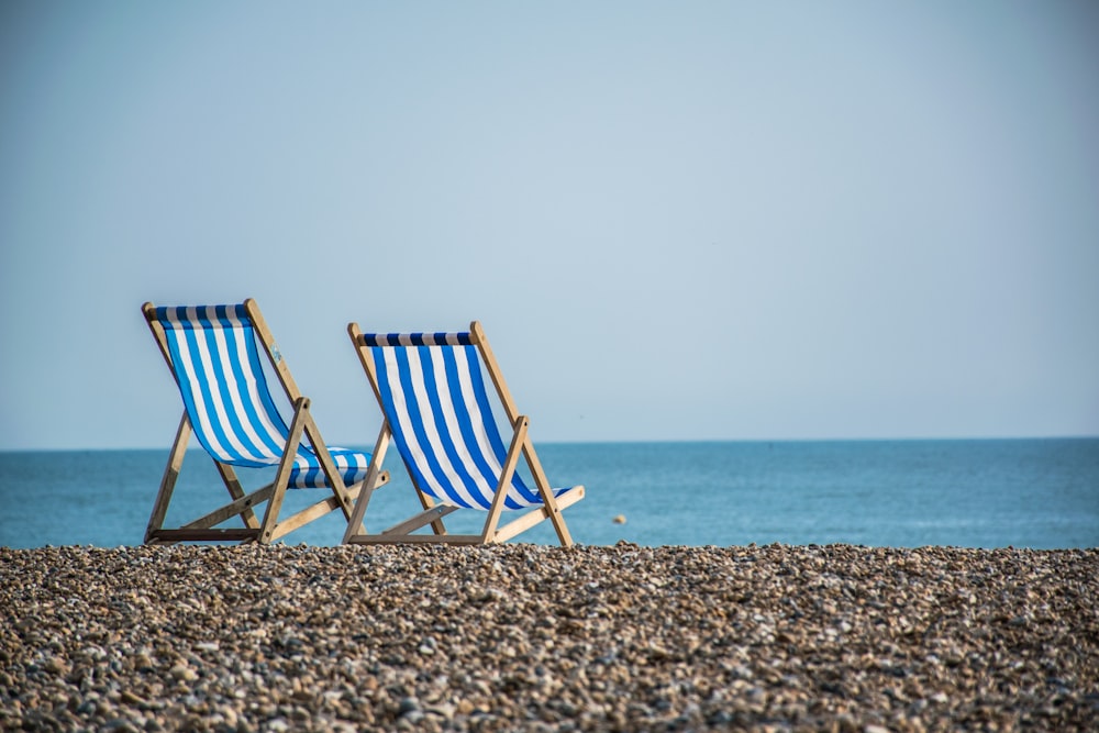 chaise pliante rayée bleue et blanche sur la plage pendant la journée