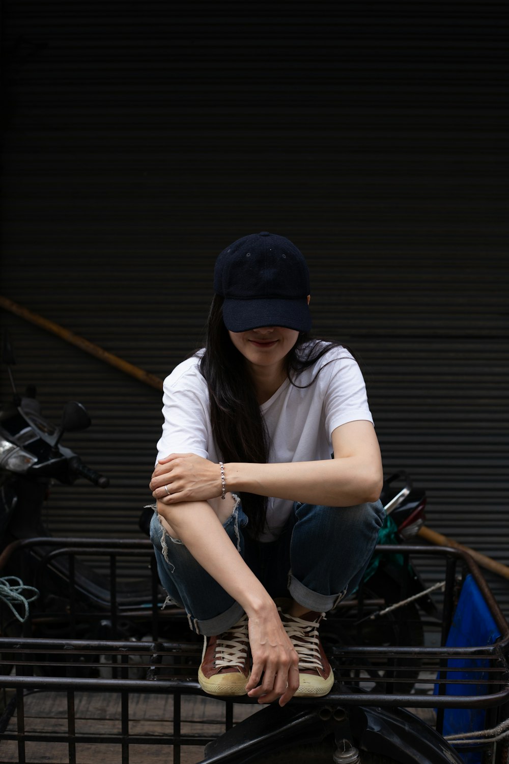 man in white t-shirt and blue cap sitting on black motorcycle