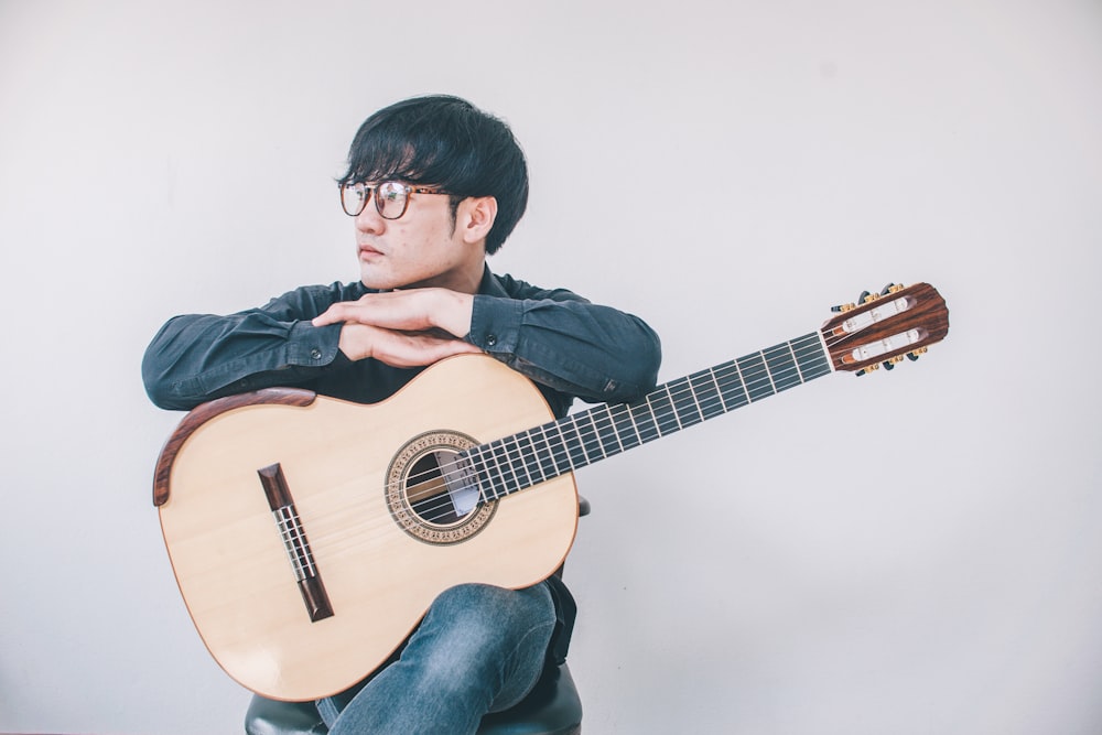 man in black jacket playing guitar