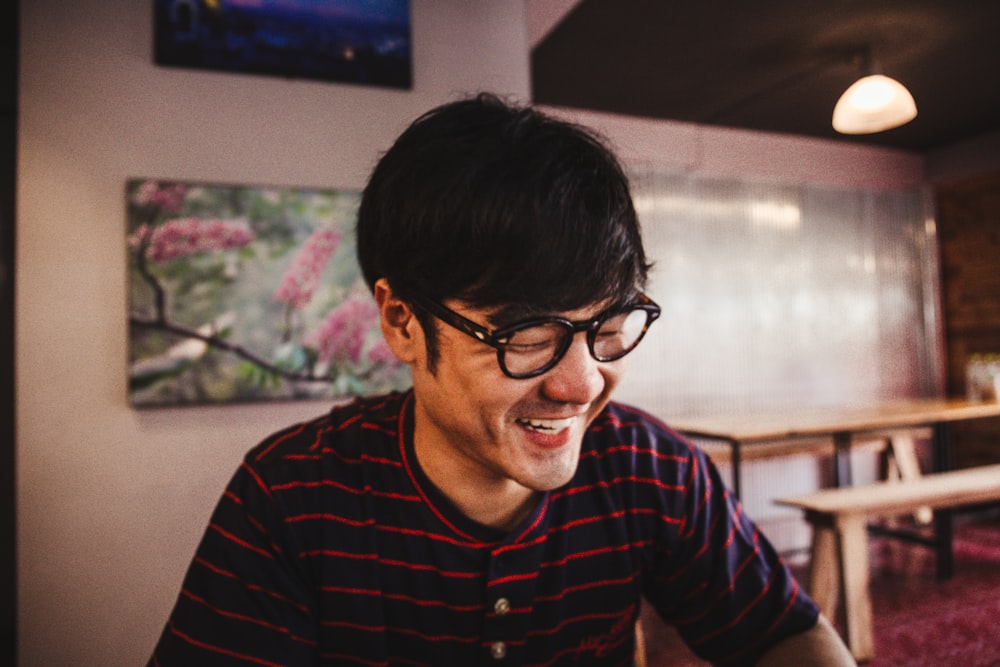 man in red and black striped long sleeve shirt wearing black framed eyeglasses