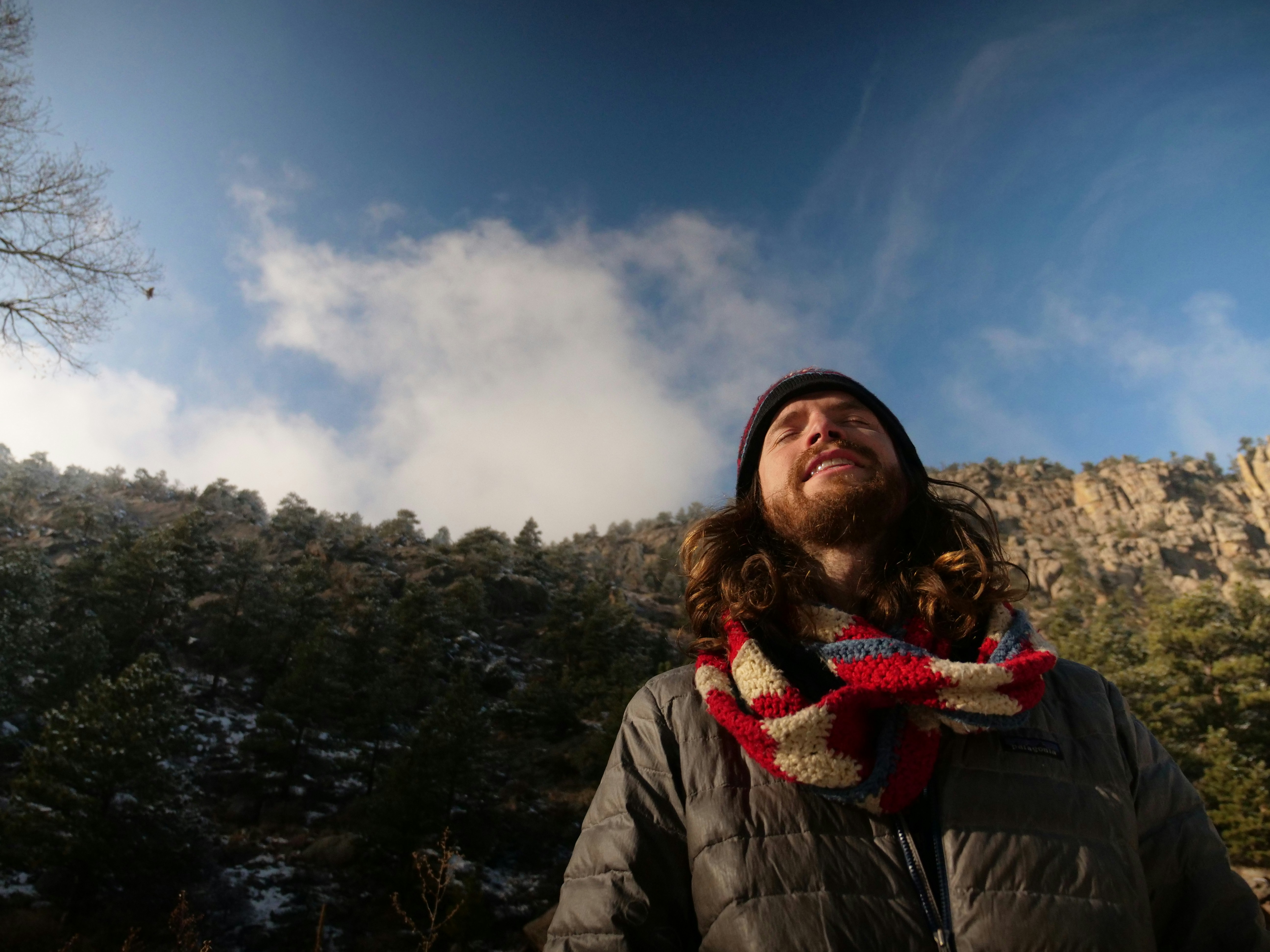 woman in black leather jacket standing on mountain under blue sky during daytime