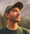 man in green crew neck shirt and black hat