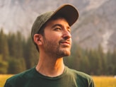 man in green crew neck shirt and black hat