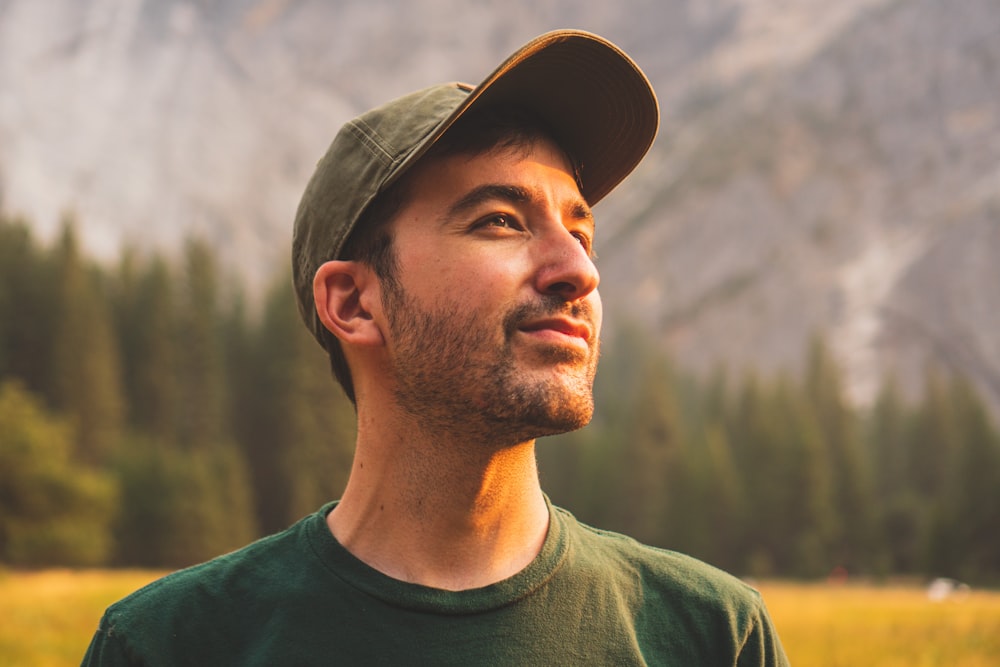 man in green crew neck shirt and black hat