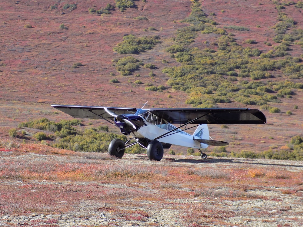 black and gray plane on brown field during daytime