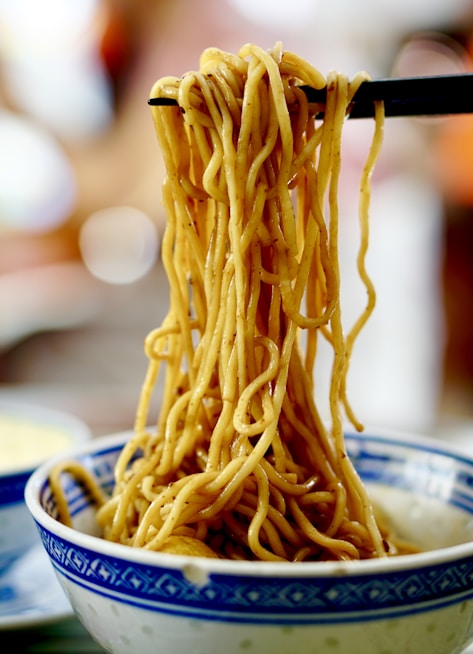 yellow pasta on blue and white ceramic bowl