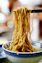 yellow pasta on blue and white ceramic bowl