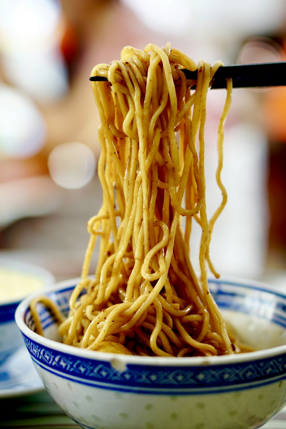 yellow pasta on blue and white ceramic bowl