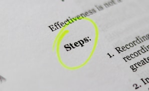 A close-up of a printed document with the word 'Steps' highlighted in bright yellow. The text appears to be part of a list or instructions, noted by the numbered points visible on the right.
