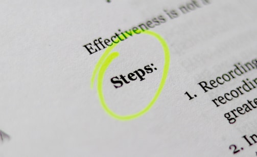 A close-up of a printed document with the word 'Steps' highlighted in bright yellow. The text appears to be part of a list or instructions, noted by the numbered points visible on the right.