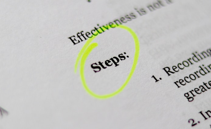 A close-up of a printed document with the word 'Steps' highlighted in bright yellow. The text appears to be part of a list or instructions, noted by the numbered points visible on the right.