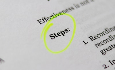 A close-up of a printed document with the word 'Steps' highlighted in bright yellow. The text appears to be part of a list or instructions, noted by the numbered points visible on the right.