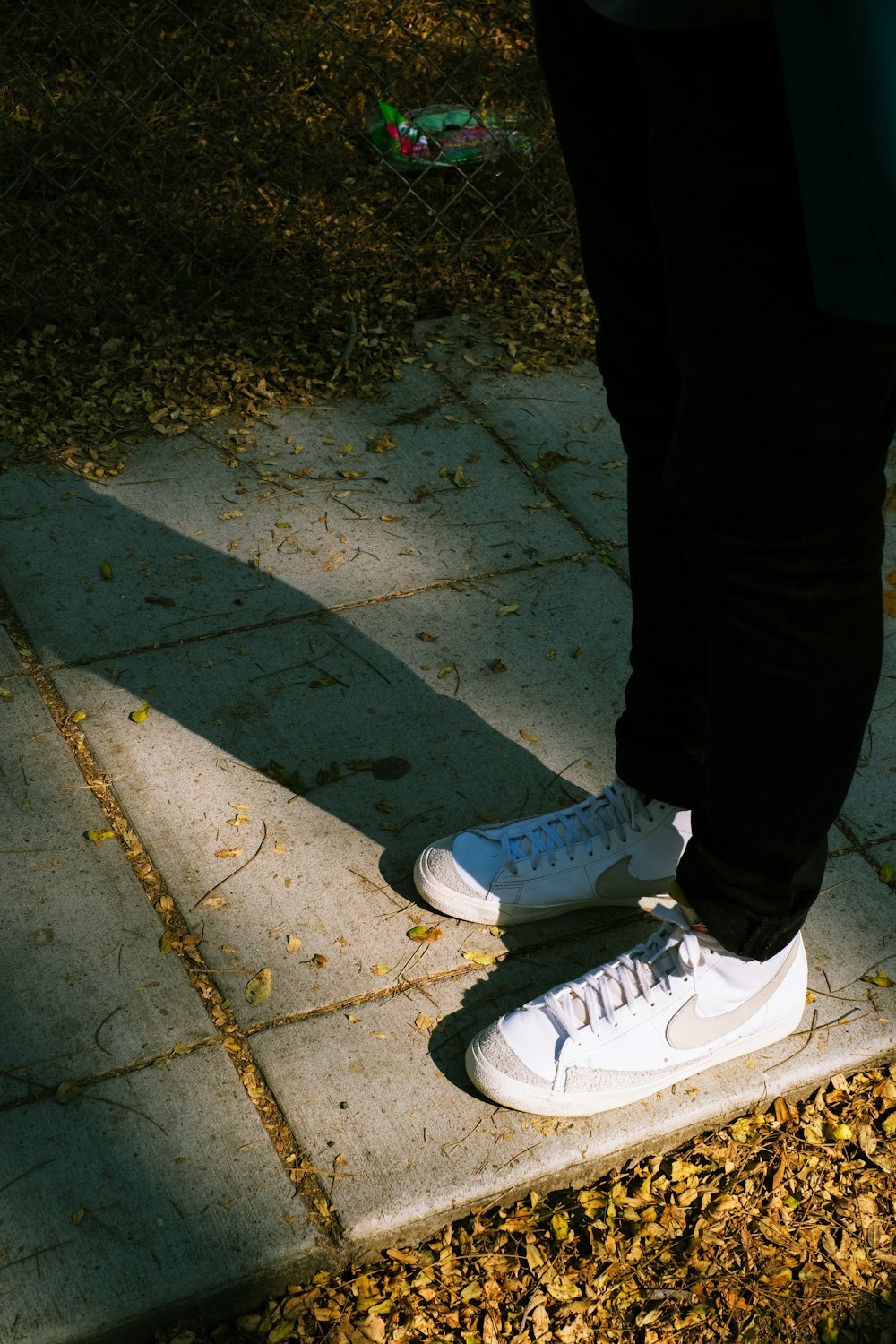 person in black pants and gray nike sneakers