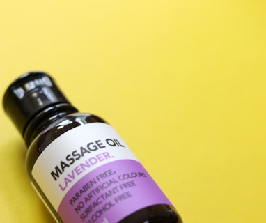 a bottle of massage oil sitting on a yellow surface