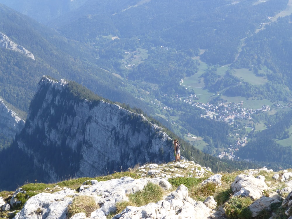 Persona che si leva in piedi sulla montagna rocciosa durante il giorno