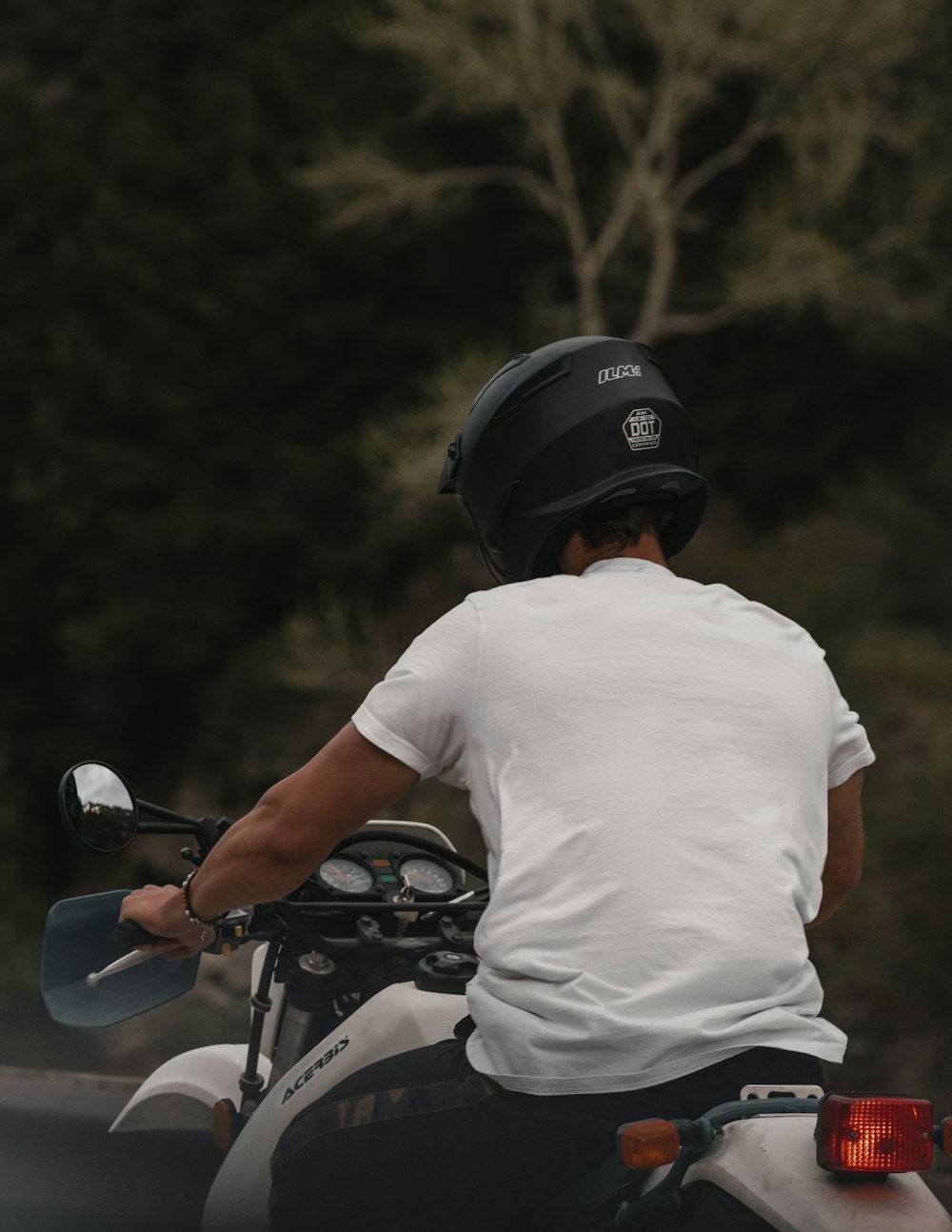 man in white t-shirt riding motorcycle