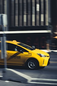 yellow taxi cab on road during daytime