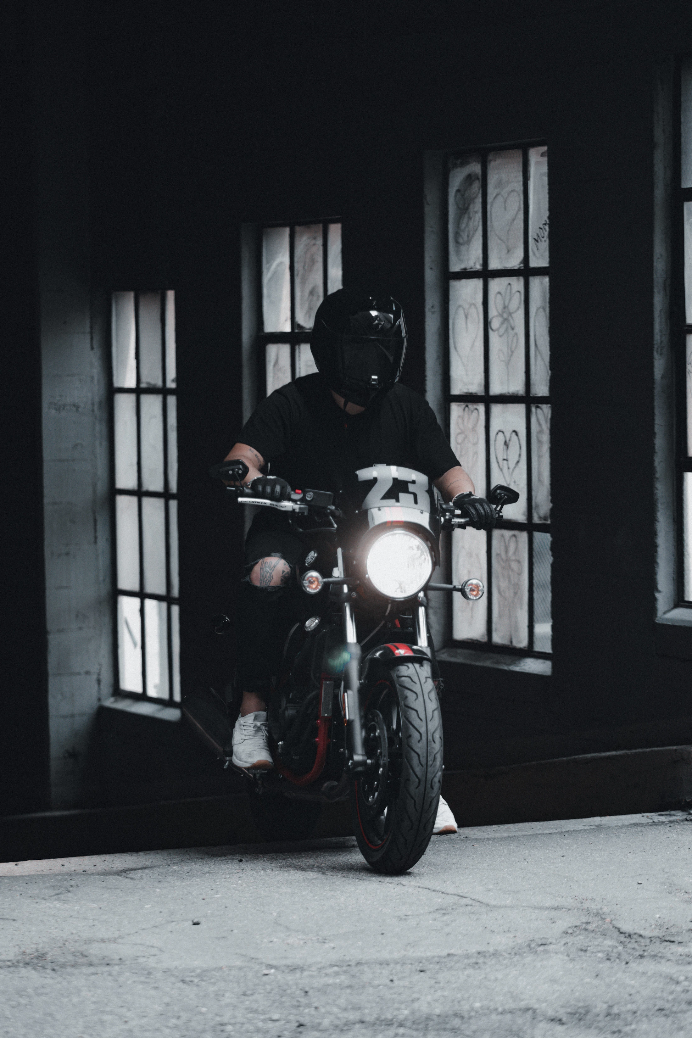 Motorcycle rider in black riding gear on a dark custom motorcycle