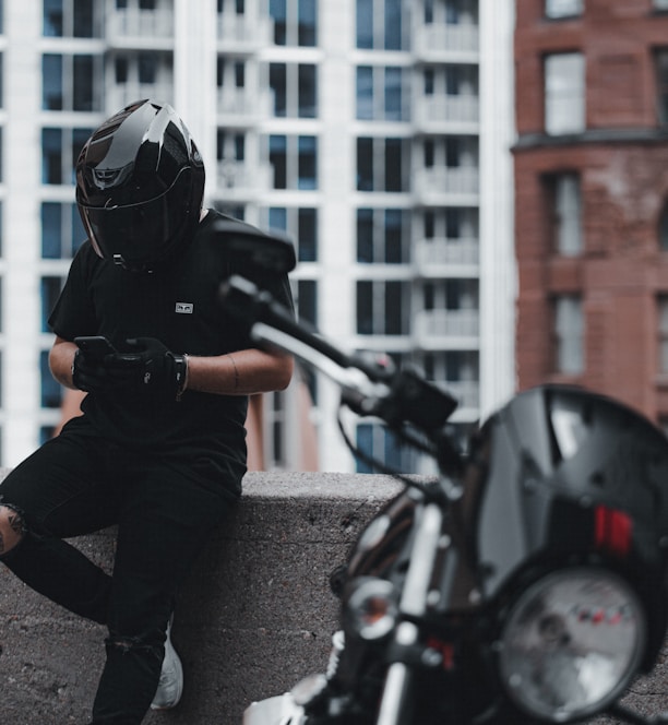 man in black jacket and gray pants wearing black helmet riding motorcycle during daytime