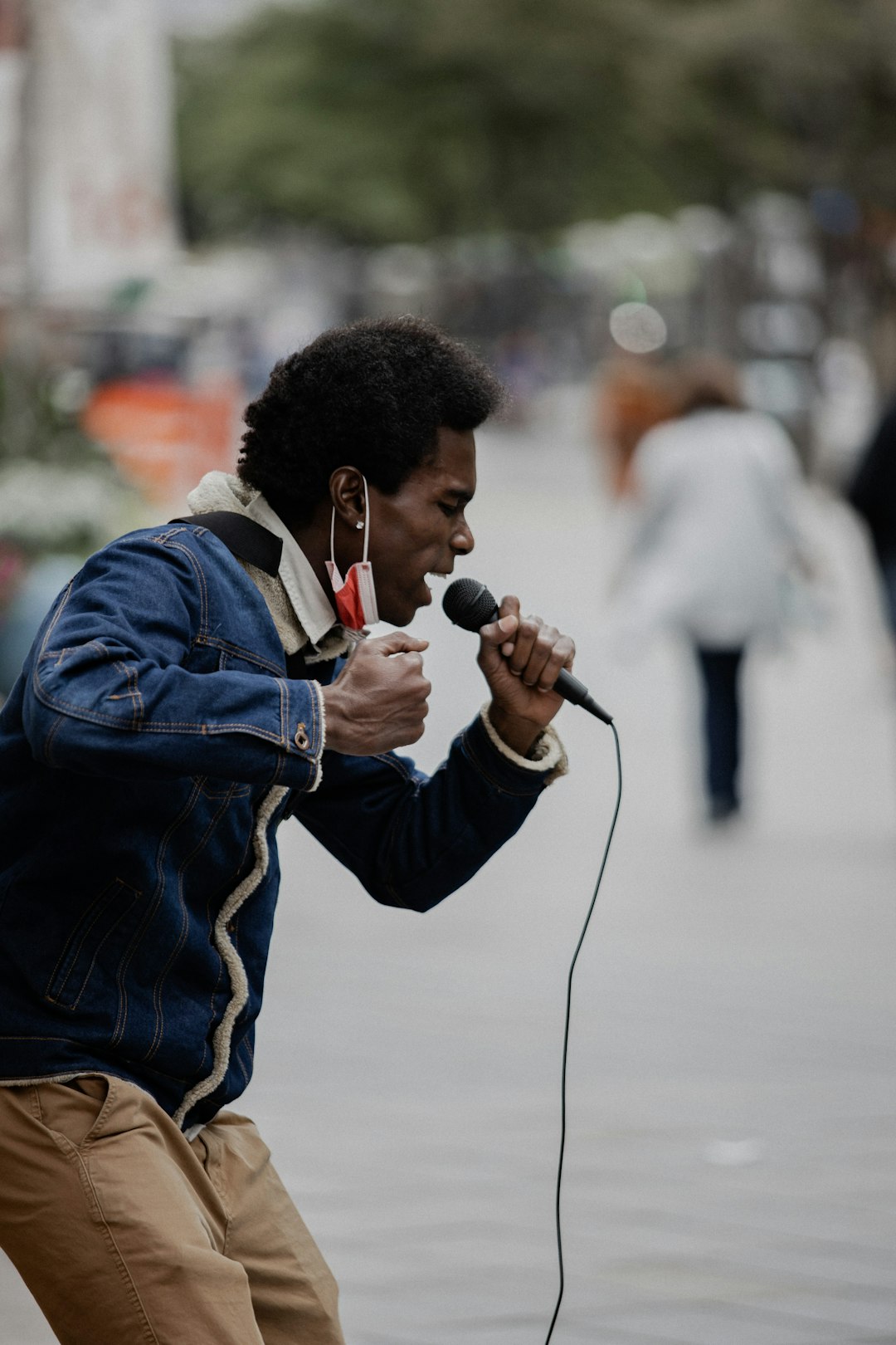 man in blue jacket holding microphone