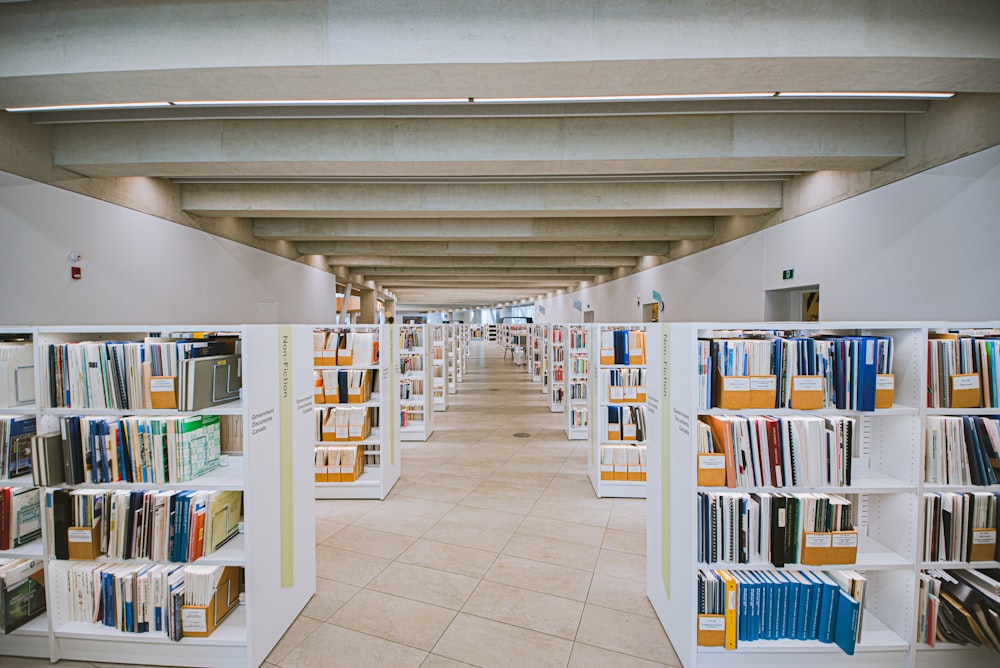 white wooden book shelves on white tiled floor