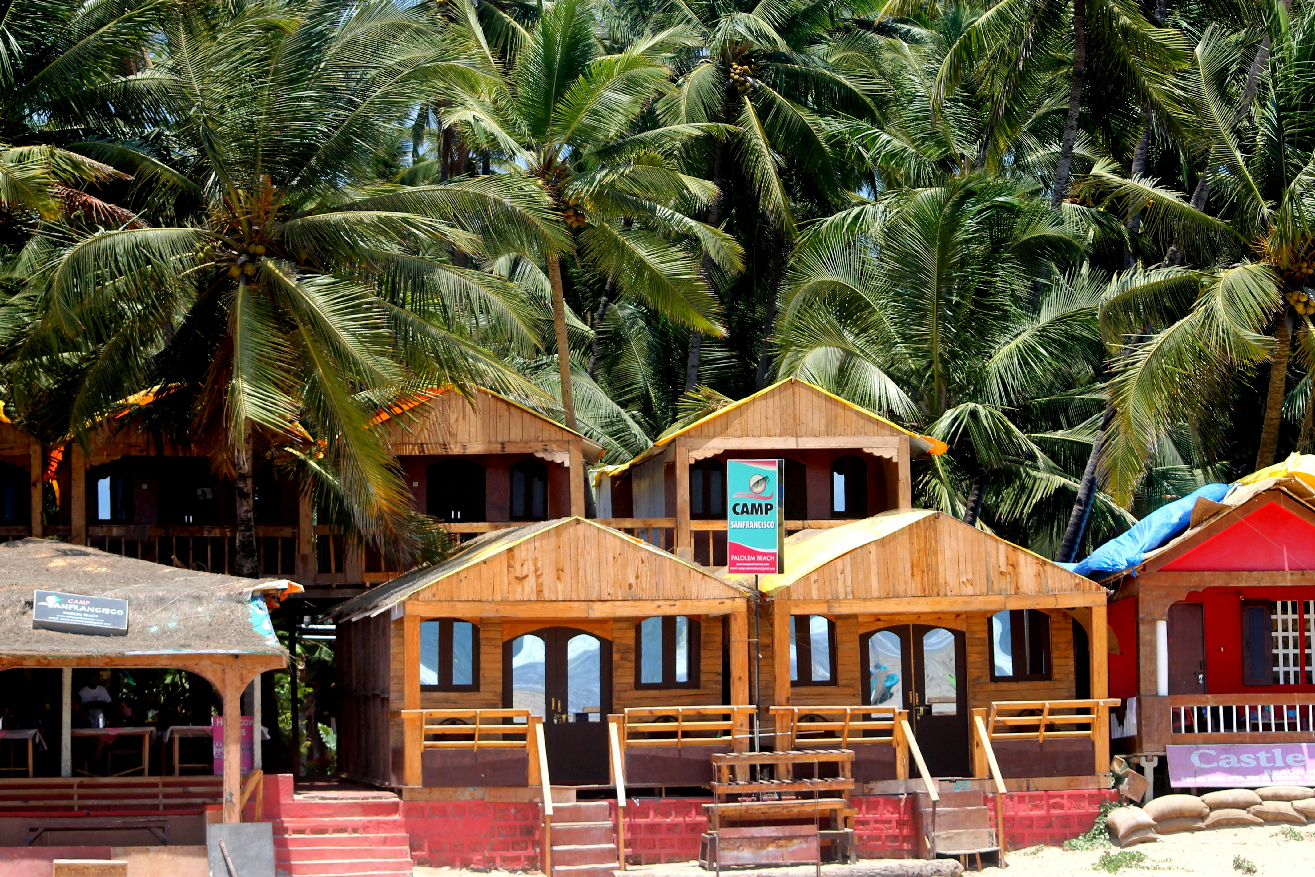 brown wooden house surrounded by palm trees