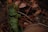 A collection of green and brown leaves intertwined with thin twigs and branches, set against a backdrop of natural stones. The scene is earthy and rich in textures, with a focus on the subtle variations in leaf color and form.