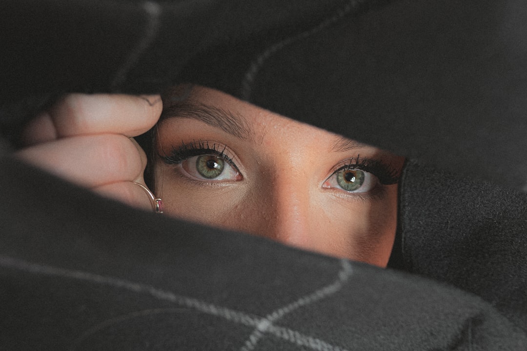 woman covering her face with black and white textile