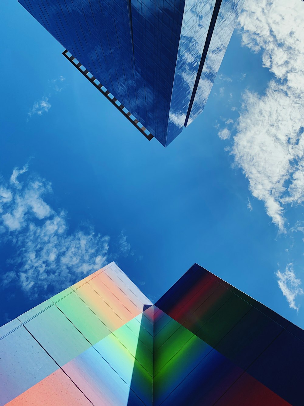 Edificio de vidrio azul, verde y blanco bajo el cielo azul