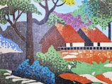 A large mosaic mural depicting a vibrant nature scene on an outdoor wall