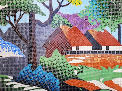 A large mosaic mural depicting a vibrant nature scene on an outdoor wall