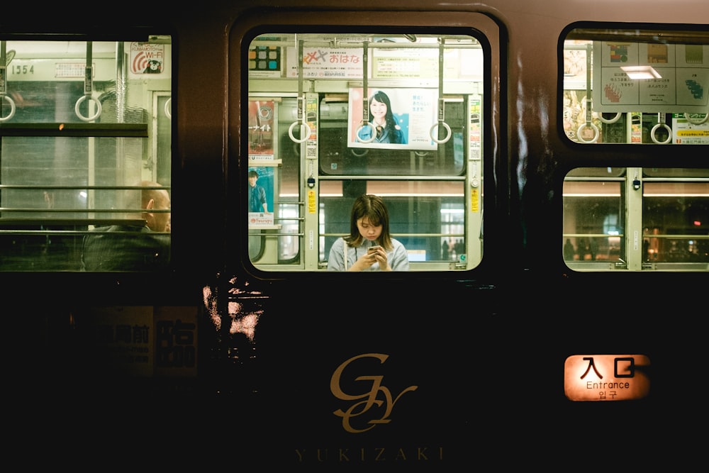 man in white dress shirt sitting inside train