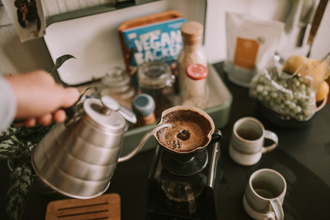 person pouring coffee on cup