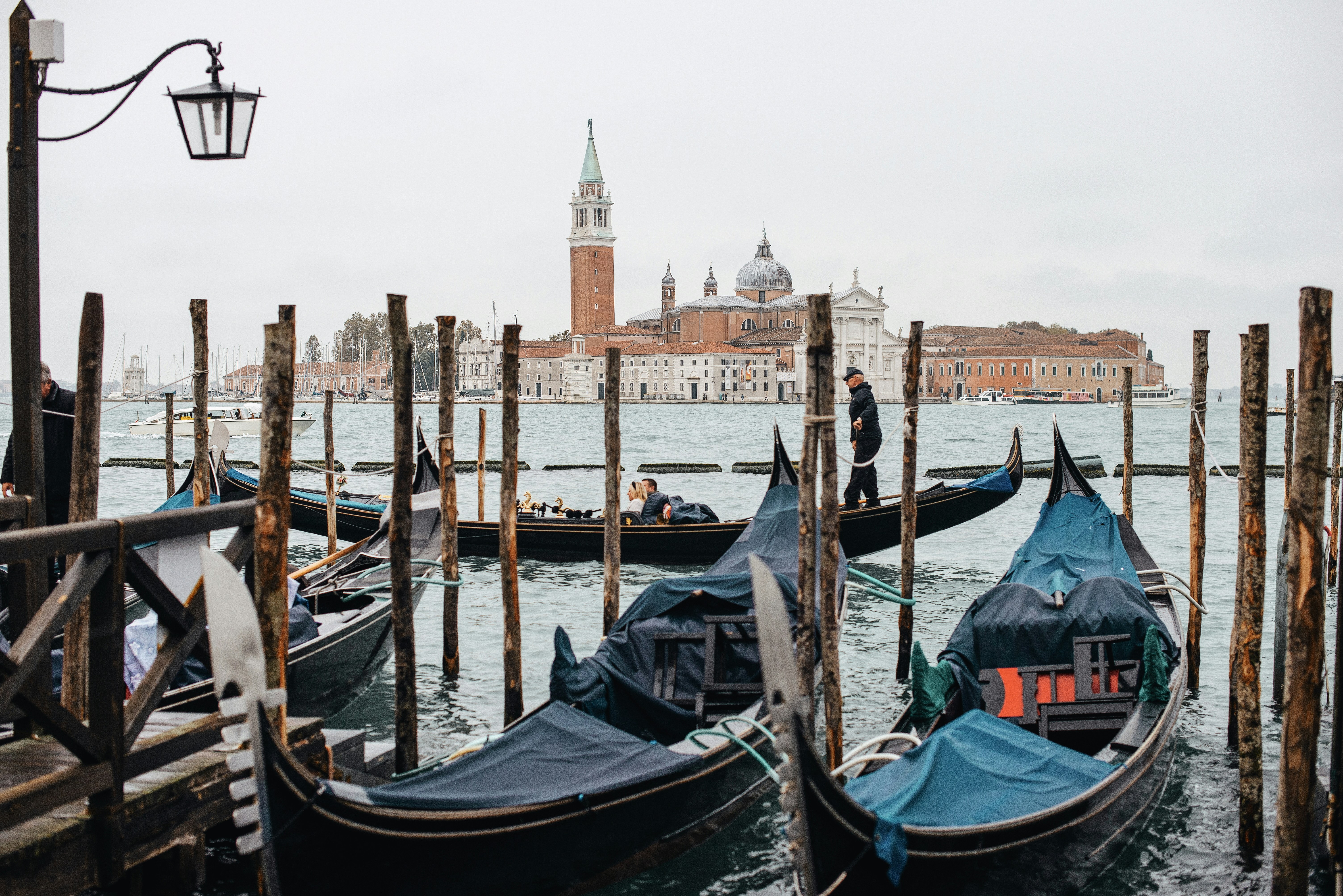black boat on body of water near brown concrete building during daytime