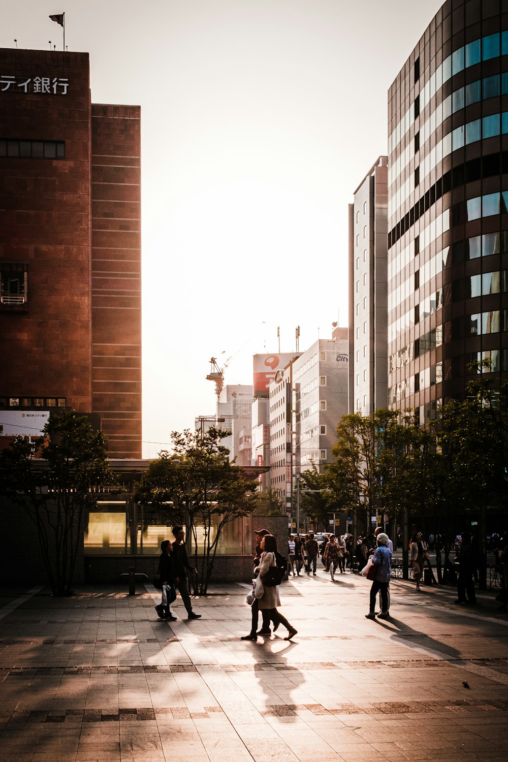 people walking on sidewalk near high rise buildings during daytime