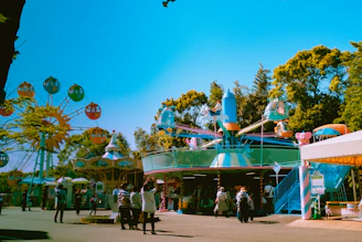people riding on green and yellow carousel during daytime