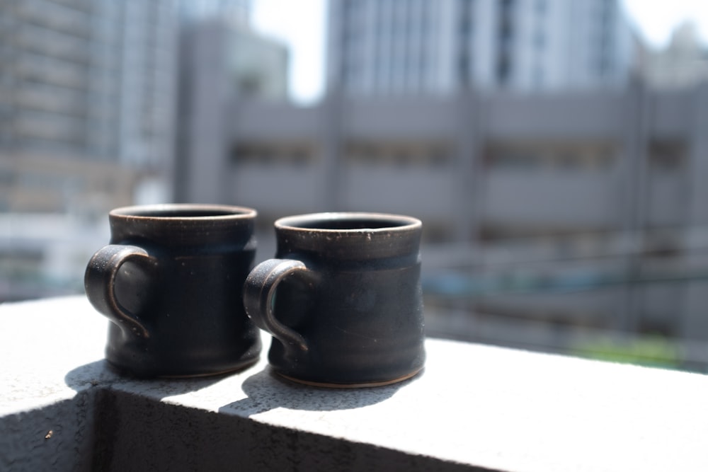black ceramic mugs on white table