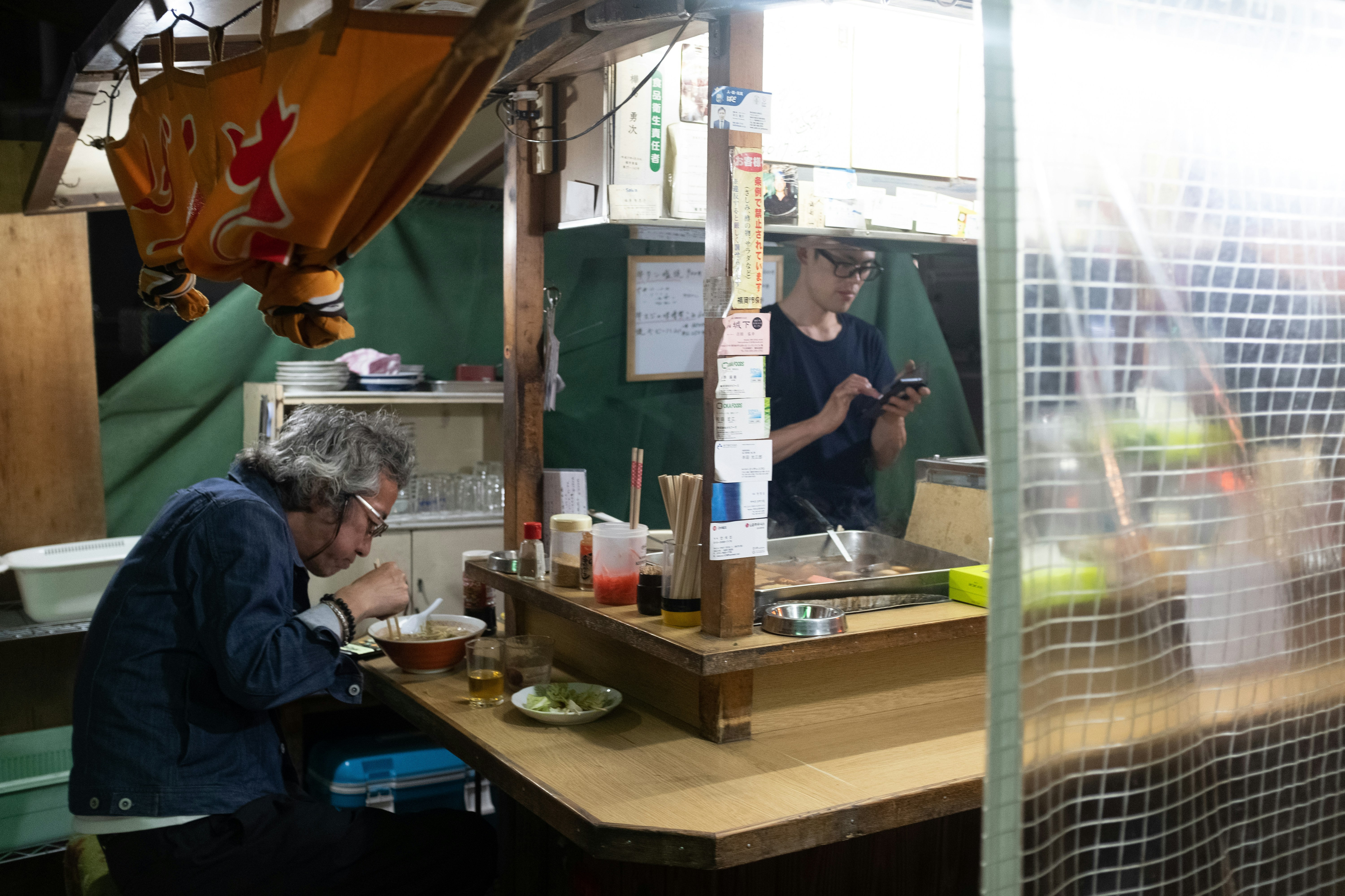 man in blue dress shirt standing beside man in green dress shirt, 