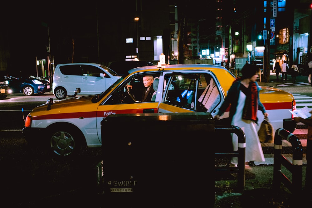 yellow and black taxi cab on the street during night time