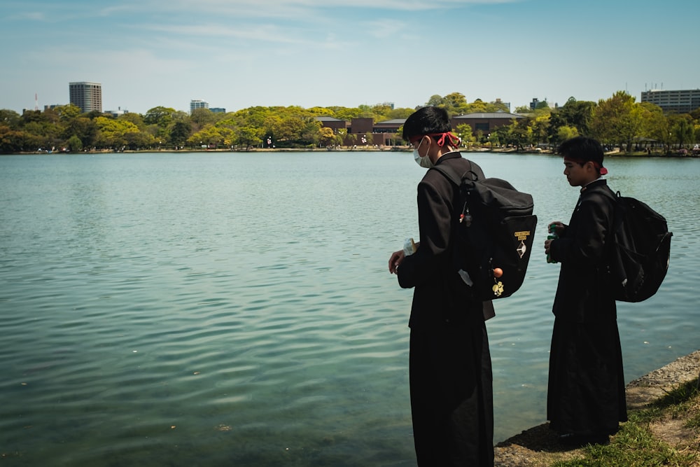 man in black coat standing near body of water during daytime