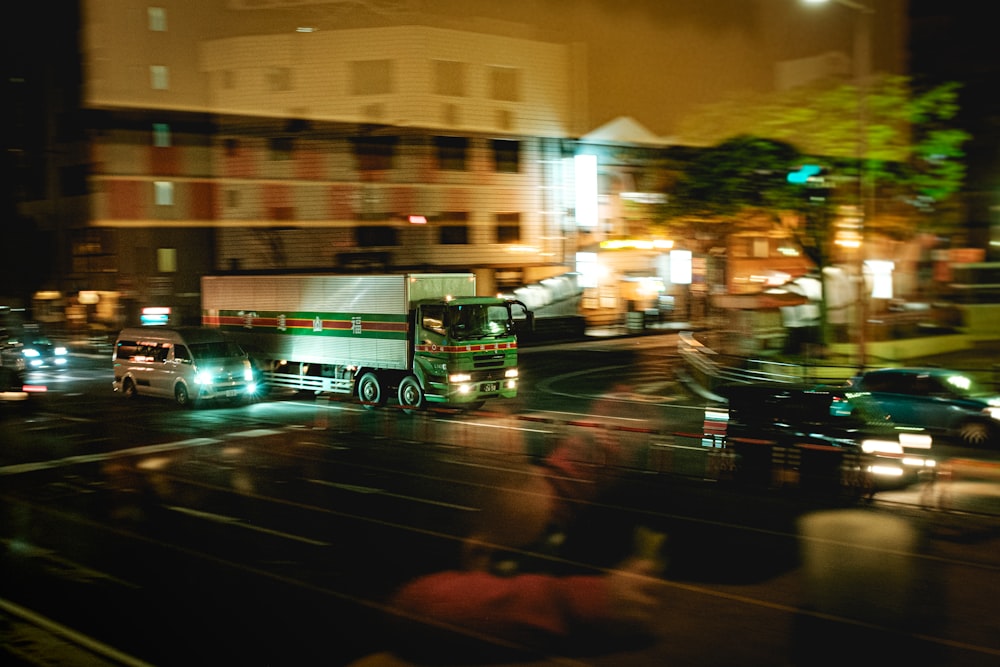 夜間の道路を走るグリーンバス