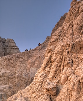 Image showing a group climbing rocky outdoor terrain under a clear sky.