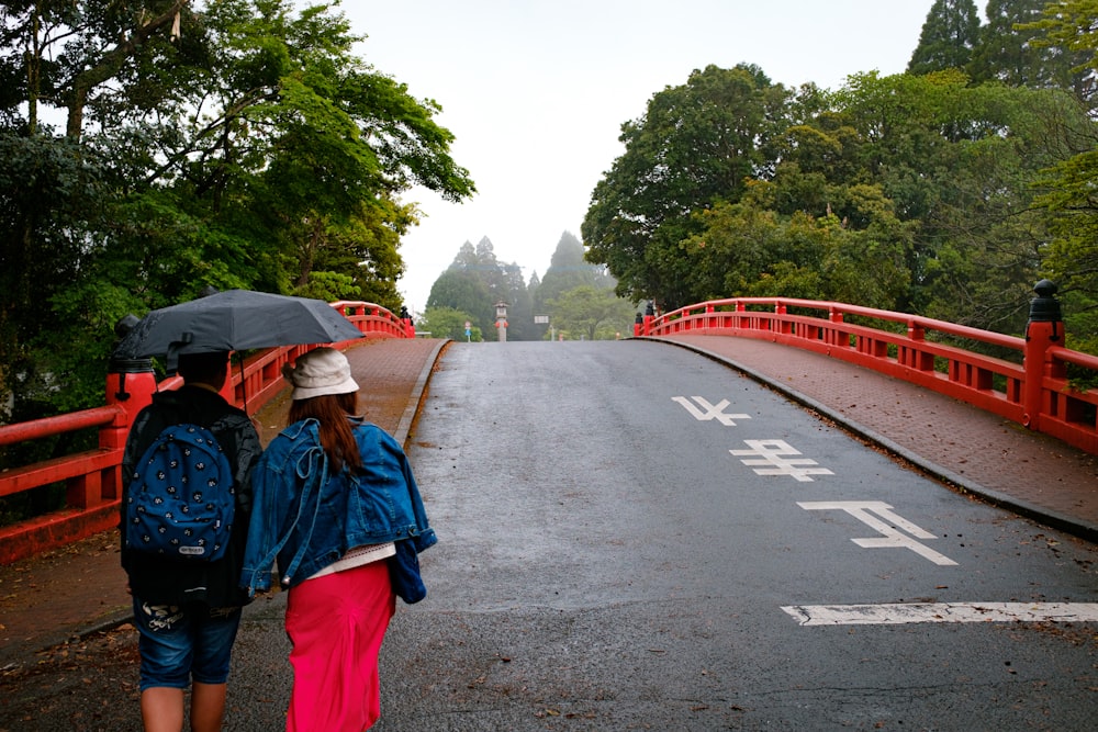 man in blue jacket and blue backpack walking on road during daytime