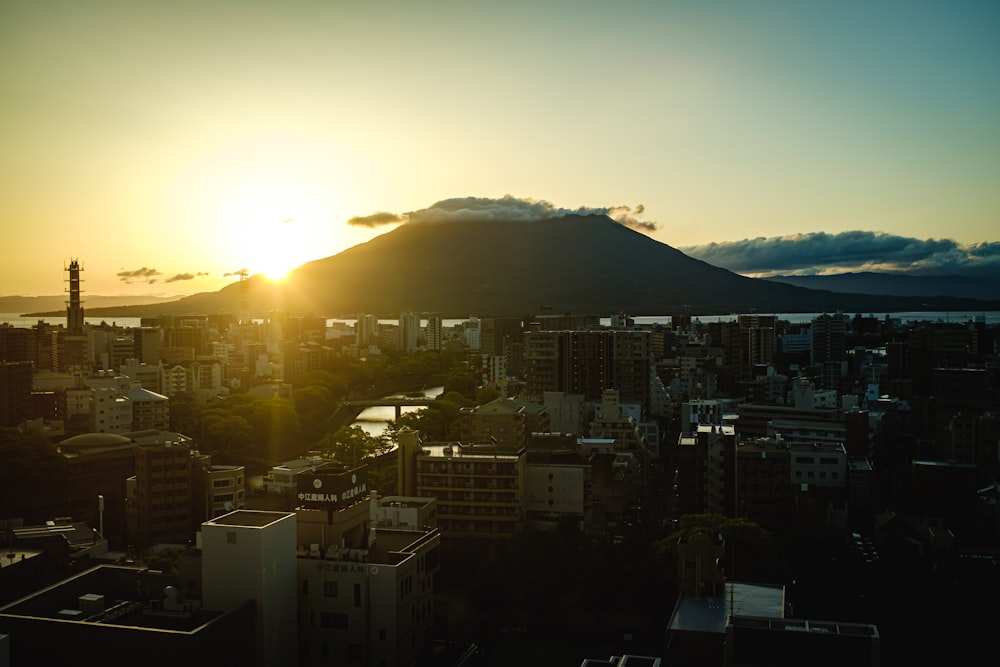 city with high rise buildings near mountain during sunrise