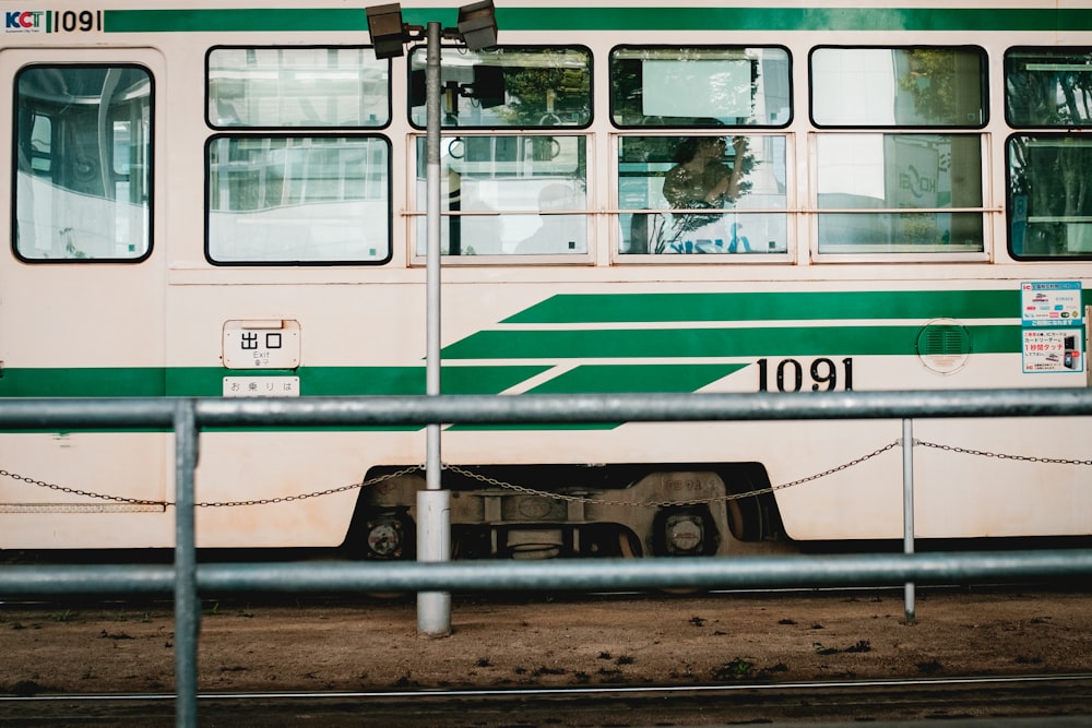 green and white train on rail tracks during daytime