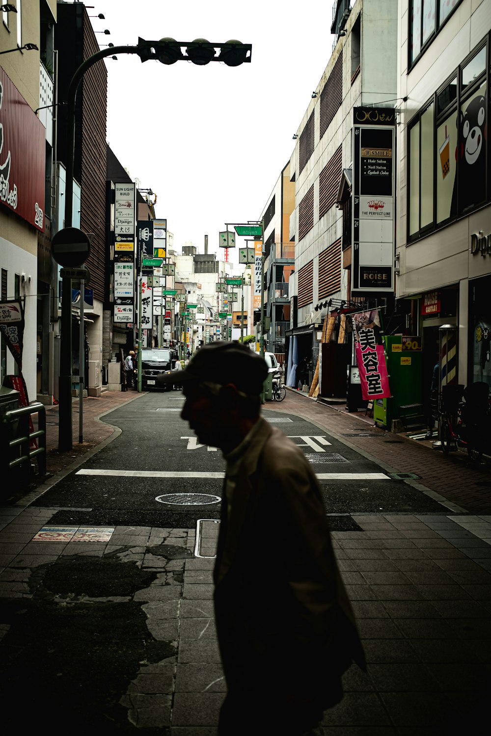 man in black coat walking on sidewalk during daytime