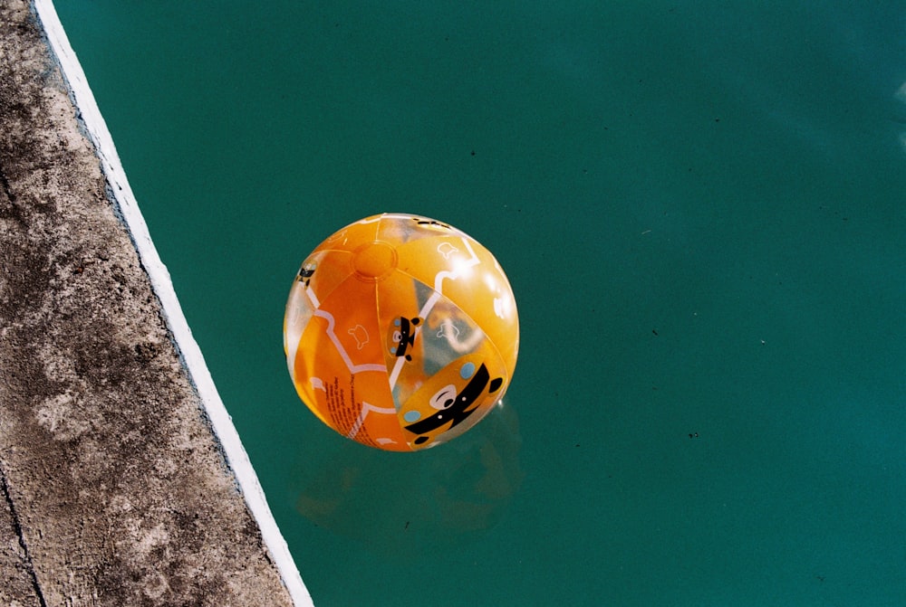 yellow and white balloon floating on water